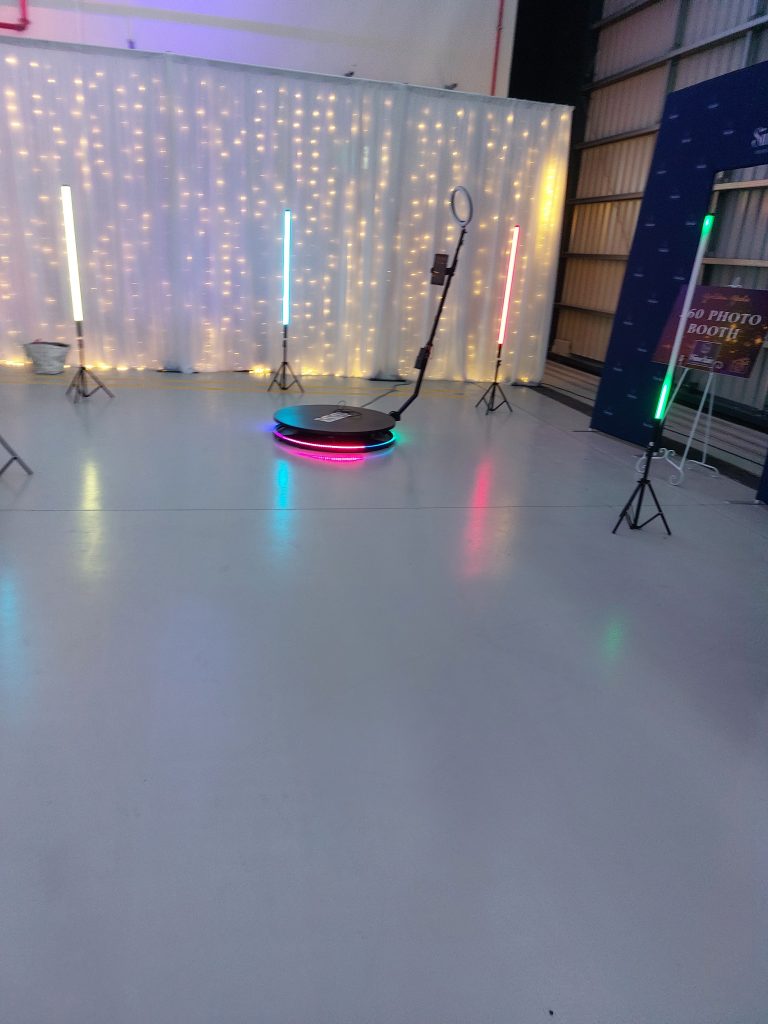 Memories Made and Personalised - Memories Made and Personalised - Photo Booth Area with Vertical Led Light Bars, a Ring Light on a Stand, and a String‑lit Backdrop Behind a White Curtain. -  - 360 Photo & Video Booth Hire | Mmp Events -  - 360 Photo & Video Booth Hire | Mmp Events